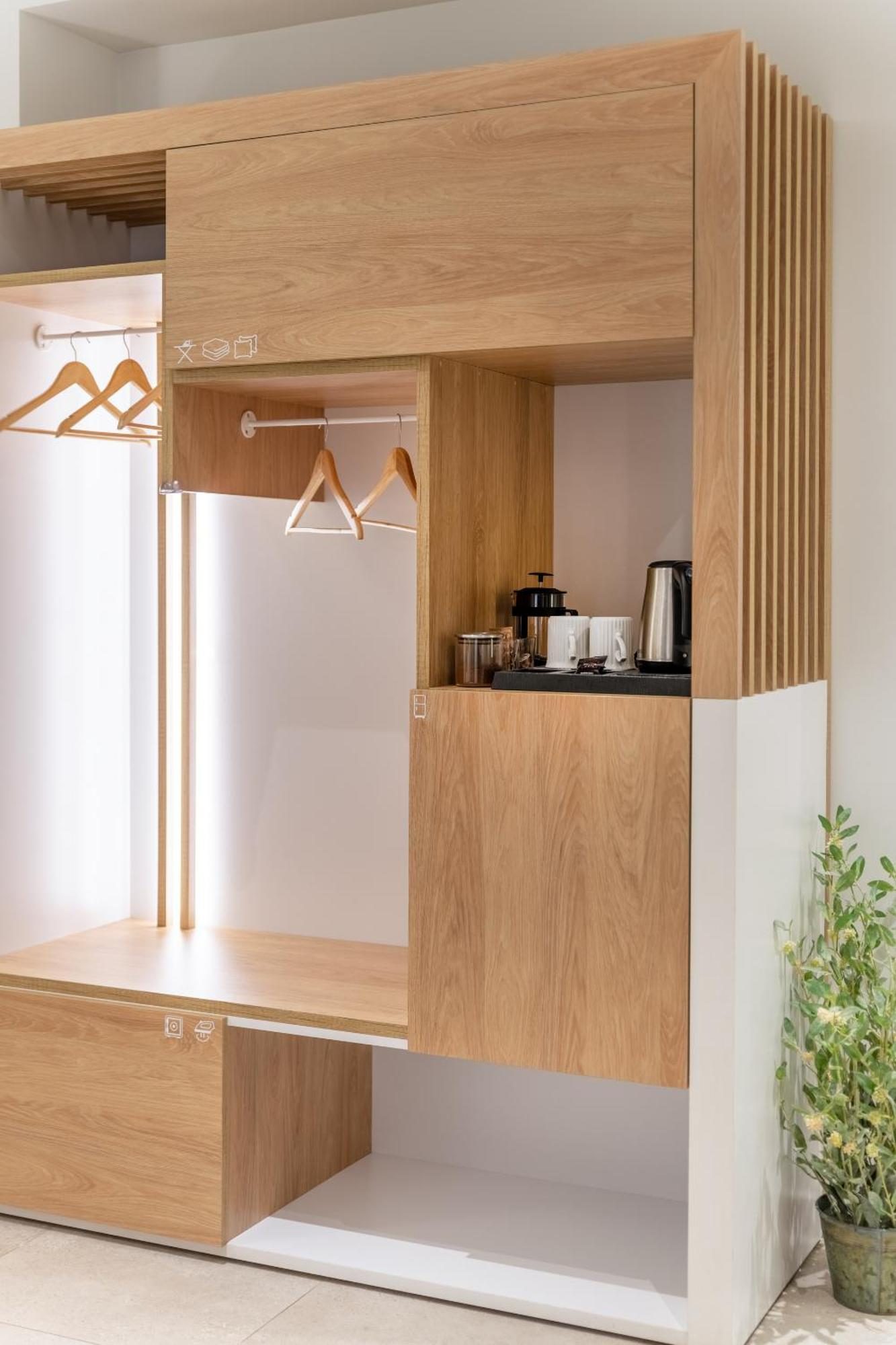 Oak coffee corner with machine, kettle, cups and a minibar fridge below