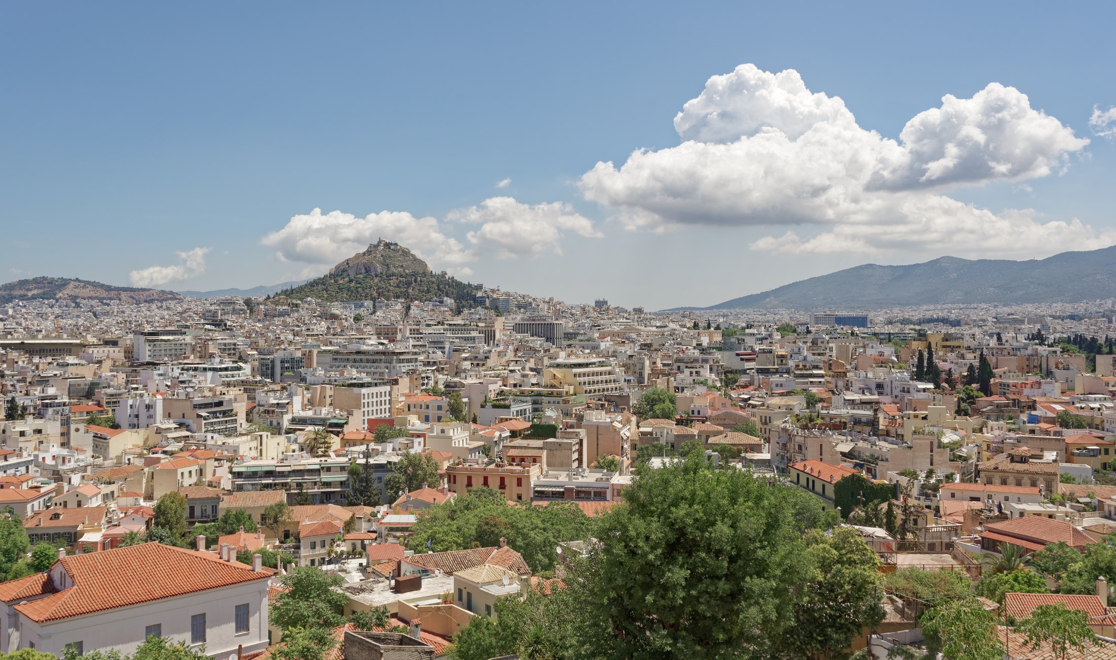 Central Athens seen over the rooftops from the slopes of the Acropolis, with Lycabettus hill in the distance